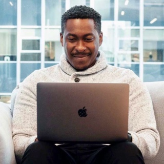 photo of Wembley sitting and typing on a laptop